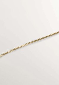 Cadena de metal dorado con eslabones ovalados alargados, con un acabado suave y una forma uniforme, reposando plana sobre un fondo claro.