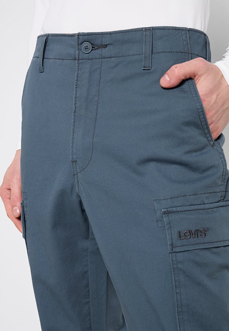 Die blauen Cargo-Hosen von Levi's bestehen aus strukturiertem Stoff, verfügen über seitliche Taschen und ein Logo-Patch am rechten Oberschenkel. Sie haben einen Knopfverschluss an der Taille.