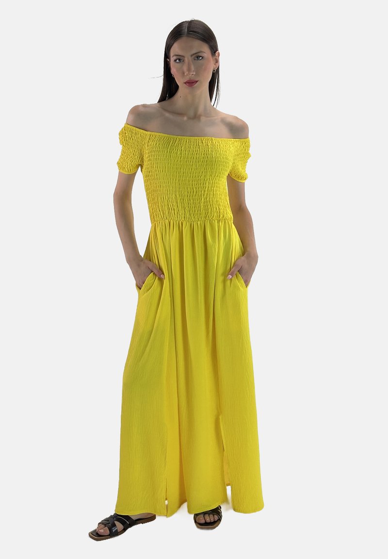 Abito maxi giallo senza spalline con corpetto arricciato, maniche corte a sbuffo e tasche laterali; presenta un tessuto testurizzato e fluido.