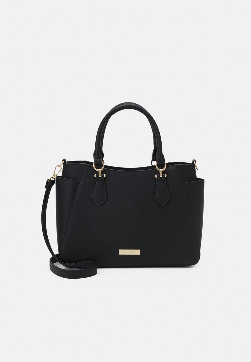 Sac à main structuré noir avec doubles poignées, bandoulière détachable, poches latérales et éléments dorés sur fond uni.