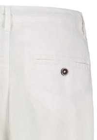 White linen pants featuring a back pocket with a round brown button and a flat waistband, showcasing a soft, textured fabric.