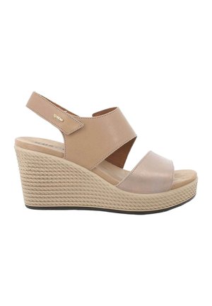 Sandalo beige con zeppa, suola piatta testurizzata, due ampie cinghie incrociate e cinturino posteriore regolabile con chiusura in Velcro.