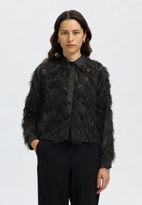 Black sheer shirt featuring textured, feather-like detailing, a classic collar, and long sleeves with a solid black band at the cuffs.