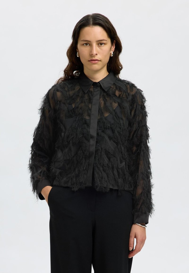 Black sheer shirt featuring textured, feather-like detailing, a classic collar, and long sleeves with a solid black band at the cuffs.