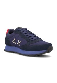 Sneaker blu navy con una combinazione di materiali tessili e scamosciati, caratterizzate da un contraddistinto tallone rosso, una suola intermedia viola e accenti bianchi del logo.