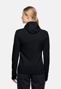 Felpa nera con zip, dal design aderente, realizzata in tessuto testurizzato e con cappuccio regolabile. Presenta maniche lunghe con fori per i pollici e lati senza cuciture.