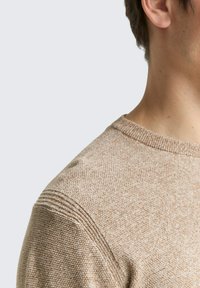 Hellbrauner gestrickter Pullover mit strukturiertem Stoff, Rundhals-Ausschnitt und Rippdetails an den Schultern. Einfaches Design mit subtilen Akzenten.