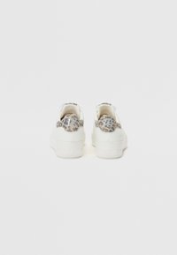 Witte sneakers met een textuur van luipaardprint aan de achterkant, met een vetersluiting en subtiele branding op de hiel. Gladde voorkanten, duurzaam materiaal.