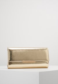 Złota metaliczna kopertówka o gładkiej fakturze, prostokątnym kształcie i magnetycznym zamknięciu. Na przedniej części znajduje się subtelny akcent w postaci logo.