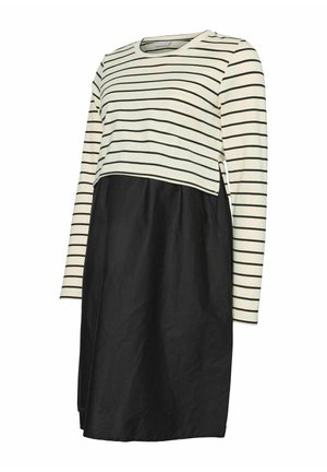 Kremkrāsas un melnā svītrainā piedurknēm topa ar melnu apakšu. Iezīmē brīvu piegriezumu un divkrāsu dizainu ar taisnu griezumu.