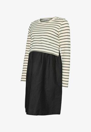 Kremkrāsas un melnā svītrainā piedurknēm topa ar melnu apakšu. Iezīmē brīvu piegriezumu un divkrāsu dizainu ar taisnu griezumu.