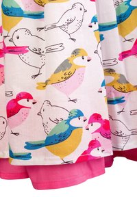 Tkanina bawełniana z kolorowym wzorem ptaków w odcieniach różu, żółci, niebieskiego i zielonego, z gładkim różowym obszyciem na dole.