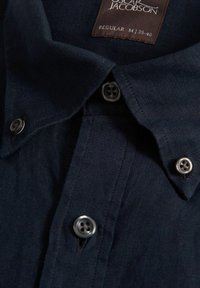 Camicia di lino blu navy con colletto button-down, caratterizzata da bottoni neri in contrasto e un'etichetta con la scritta "Oscar Jacobson, Regular M 39-40."