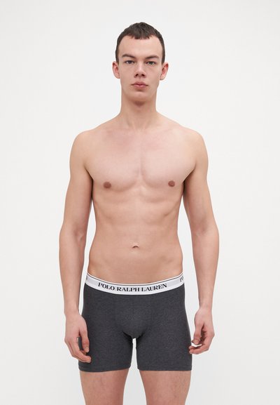 Grijze boxershorts met een witte tailleband waarop "POLO RALPH LAUREN" staat. De stof lijkt glad met een aansluitend ontwerp en minimale naden.