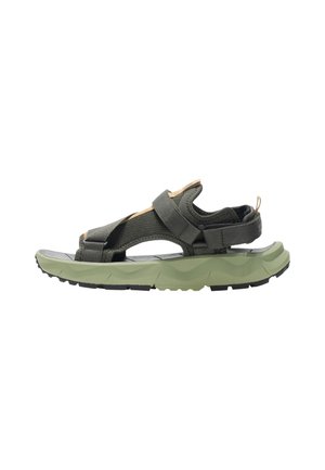 Outdoor sandaal met verstelbare donkergroene riemen en een dikke lichtgroene zool, ontworpen voor comfort en robuust gebruik.