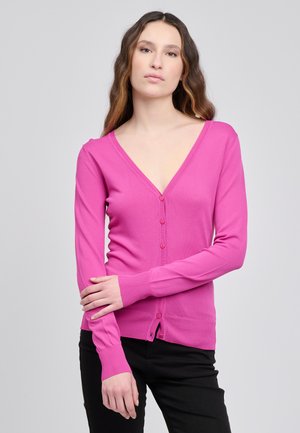 Cardigan rosa aderente con scollo a V profondo, maniche lunghe e chiusura con bottoni. Polsini e orlo a costine aggiungono texture al tessuto a maglia liscio.