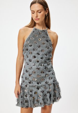 Grijze halterjurk met franjerstructuur, versierd met metalen bloemsequins en een uitlopende zoom. Eenvoudig ontwerp en lichtgewicht materiaal.