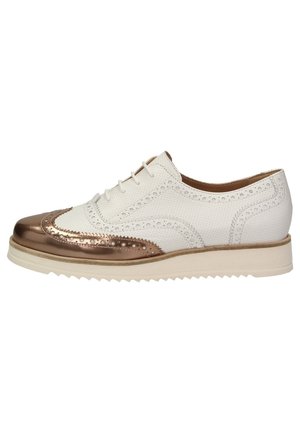 Witte geperforeerde leren brogue-schoen met metallic bronzen neuskap, crèmekleurige zool en decoratieve geponste details, zijwaarts bekeken.