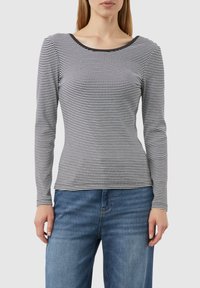 Langarmshirt mit gestreiftem Schwarz-Weißen Muster, Rundhalsausschnitt, figurbetonter Silhouette und weicher Stofftextur. Getragen mit blauen Jeans.