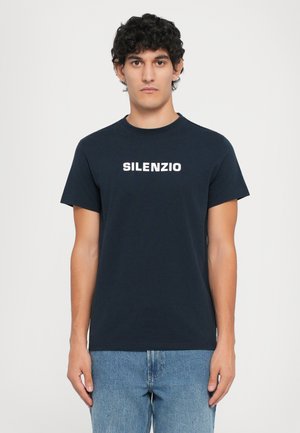 Tricou din bumbac de culoare bleu marin, cu guler rotund și mâneci scurte. Prezentă un text alb "SILENZIO" centrat pe piept.