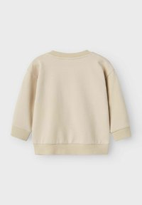 Beige, pehmeä puuvillapaita, jossa on pyöreä pääntie, resorit hihoissa ja helmassa. Ominaisuuksiin kuuluu minimalistis design ja rento istuvuus.
