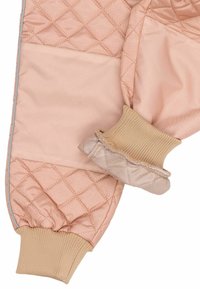 Tissu matelassé rose rembourré avec motif en losanges ; possède des poignets côtelés beiges et une texture lisse, offrant chaleur et confort.