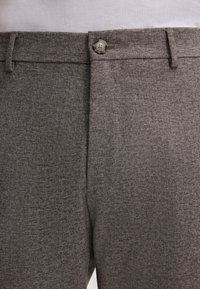 Grau gewebte Hose mit glatter Textur, featuring einen vorderen Knopf, eine einzelne Falte und seitliche Taschen für praktische Nutzung.