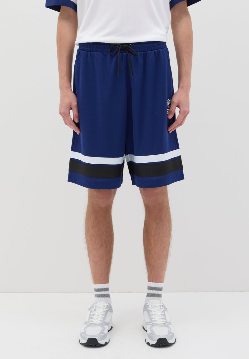 Shorts de sport navy en tissu respirant, ornés de stripes horizontales blanches et noires près de l'ourlet et dotés d'une taille élastique.
