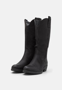 Bottes noires montant jusqu'aux genoux, fabriquées en matière douce et texturée, avec un haut courbé et des accents tressés. Talon bloc bas et robuste, avec un design à bout arrondi.