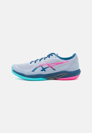Chaussure de sport grise avec des accents bleus, un logo rose et une semelle teal. Caractéristiques d'un dessus texturé et de lacets ronds, conçue pour un mouvement dynamique.
