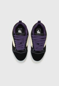 Baskets noires et crème avec des lacets violets, en suède et en maille, à bout rond, logo brodé sur la languette et semelle en caoutchouc texturé.