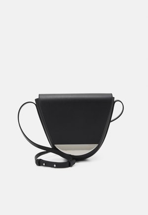 Sort læder crossbodytaske med trekantsform, buet bund, sølvmetalplade detalje og justerbar rem på hvid baggrund.