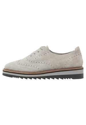 Hellgrauer Wildlederschuh im Wingtip-Stil mit perforierten Details, weiß-schwarz geschichtete Sohle mit gezacktem Rand und Schnürverschluss.