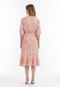 Blumenmusterkleid in Rosa, mit puffärmel, elastischem Bund und gerafftem Saum. Hergestellt aus leichtem Stoff, konzipiert für eine lockere Passform.