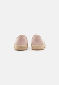 Pink suede espadrilles with woven jute soles, featuring embossed branding on the heel and a soft, rounded silhouette.