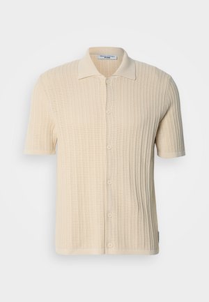 Short-sleeve cream shirt with a textured knit design, button-up front, and a classic collar. Features a ribbed pattern throughout.