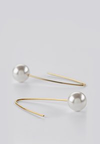 Gouden creolen met een gladde, ronde witte parelaccent. De gouden draad is dun en gebogen, wat zorgt voor een elegante, minimalistische uitstraling.