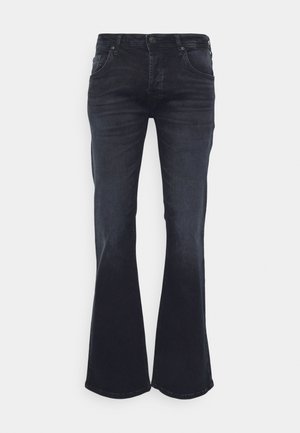 Sötét farmer, bővülő szárú nadrág, öt zsebbel, gombos záródással és övpántokkal. Simább tapintás, enyhe rugalmassággal és fokozatos bővüléssel az alján.