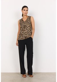 Top sin mangas de estampado de leopardo con diseño de cuello en V, combinado con pantalones negros holgados y sandalias marrones. Tela suave con una textura agradable.