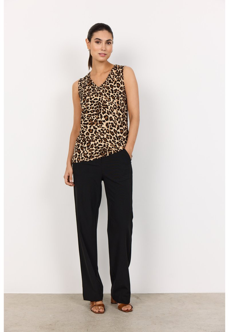 Top sin mangas de estampado de leopardo con diseño de cuello en V, combinado con pantalones negros holgados y sandalias marrones. Tela suave con una textura agradable.
