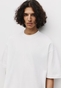 Witte katoenen t-shirt met een ronde halslijn en korte mouwen, met een ontspannen pasvorm en een zachte textuur. Eenvoudig en niet versierd ontwerp.