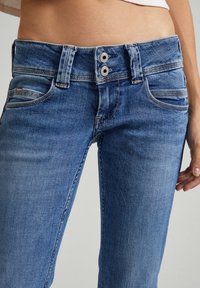 Hellblaue Denim-Jeans mit mittelhoher Taille, doppeltem Knopfverschluss und vier Taschen mit dezenten Nähdetails.