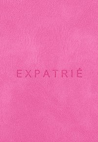Meleg rózsaszín, texturált anyag, amelyen dombornyomott betűk olvashatók: "EXPATRIÉ". Simább felület, enyhe fényességgel.
