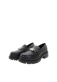 Mocasines de cuero negro con suela gruesa, que presentan un detalle de cadena plateada en la parte frontal y un acabado texturizado.
