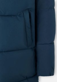  sección de chaqueta acolchada azul marino que presenta una textura suave, un bolsillo lateral y un acabado ligeramente brillante en la tela.