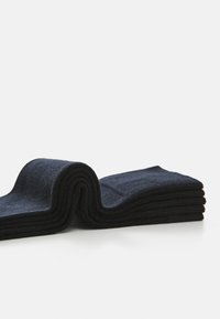 Sötétkék pamut zoknik, szépen összecsukva, textúrált felülettel. A design klasszikus alakot és egyenletes vastagságot mutat az egész területen.