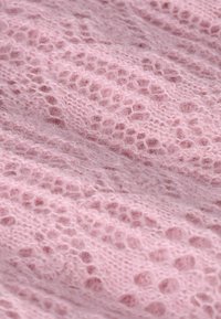 Tissu en tricot rose doux avec un délicat motif de dentelle ajourée et une texture duveteuse.