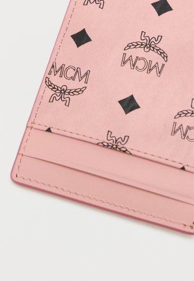 Roza usnjena denarnica z črnimi natisnjenimi logotipi in geometrijskimi vzorci. Ima gladko teksturo in šivane robove. Vidna je režnja za kartice.