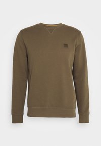 Olivgrön polotröja med lång ärm och en liten fyrkantig logotyp på vänster bröst.