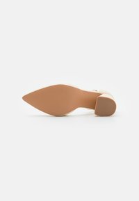 Beige korkokenkä, jossa on terävä kärki, teksturoitu pohja ja paksu korko. Minimalistinen muotoilu ilman huomattavia korostuksia tai kuvioita.